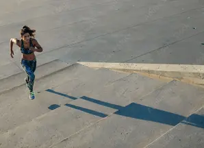 Woman running up concrete steps